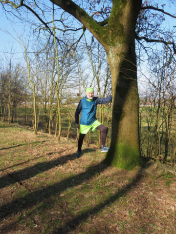 Manfred Boldt dehnt sich an einem Baum