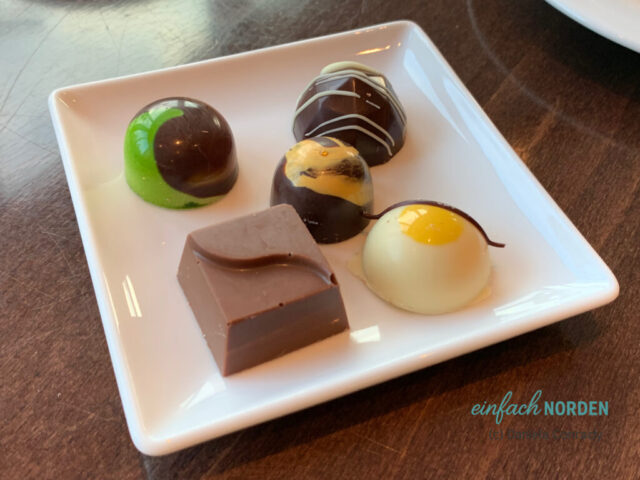 Fünf Pralinen arrangiert auf einem weißen Teller